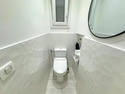a white bathroom with a toilet and a mirror at Gorgeous Oceanfront Apartment Promenade in Nice