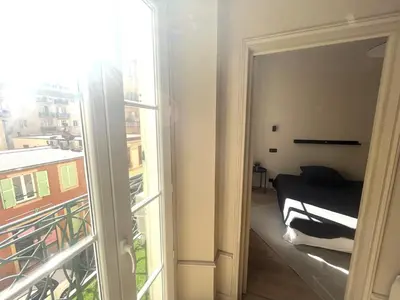 a room with a bed and a large window at Beaumont republique in Nice