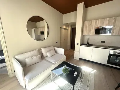 a living room with a white couch and a mirror at Beaumont republique in Nice