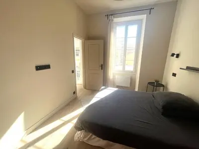 a bedroom with a bed and a window and a door at Beaumont republique in Nice