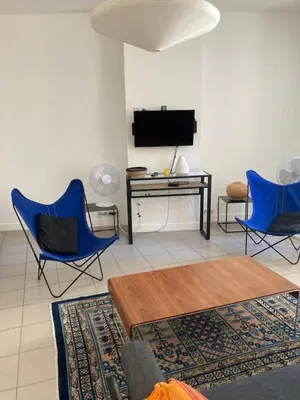 a living room with two blue chairs and a desk at L'Appartement Bleu in Nice