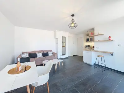 a living room with a couch and a table and chairs at Nestor&Jeeves - GIOFFREDO BELLO - central - near beach in Nice