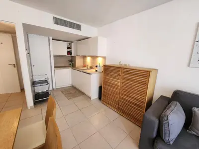 a living room with a couch and a kitchen at Appartement Nice Carré d Or in Nice