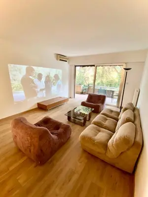 a living room with a couch and a large painting at Superbe appartement de 3p pieces dans residence avec piscine et climatisation in Nice