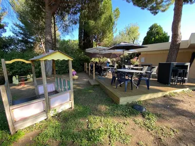 a wooden deck with a table and chairs and umbrellas at Superbe appartement de 3p pieces dans residence avec piscine et climatisation in Nice