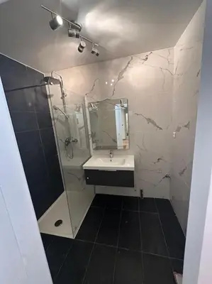 a bathroom with a shower and a sink and a mirror at Superbe appartement de 3p pieces dans residence avec piscine et climatisation in Nice