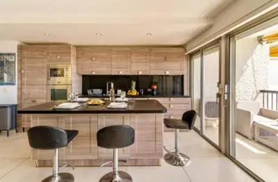 a kitchen with black bar stools and a counter at Magnificent 3 Rooms-Sea View-Terrace-Pool in Nice