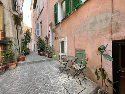 an alley with a table and chairs next to a building at Casa feracci in Villefranche-sur-Mer