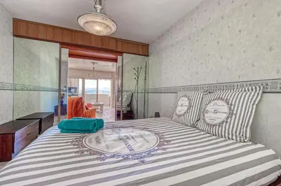 a bedroom with a large bed with a striped bedspread at 2 PIECEs BALCON VUE IMPRENABLE MER---VILLE---MONTAGNE in Nice