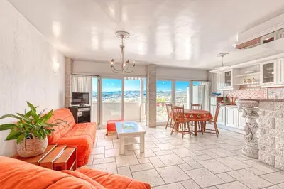 a living room with an orange couch and a table at 2 PIECEs BALCON VUE IMPRENABLE MER---VILLE---MONTAGNE in Nice