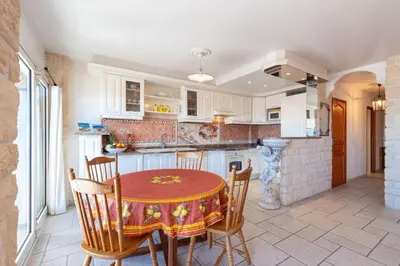 a kitchen with a table and chairs and a counter at 2 PIECEs BALCON VUE IMPRENABLE MER---VILLE---MONTAGNE in Nice