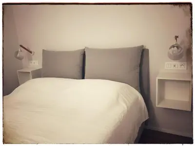 a bed with white sheets and pillows in a bedroom at Suite Offenbach FSHH in Nice