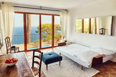 a bedroom with a bed and a table and a balcony at Best View ever! in Èze