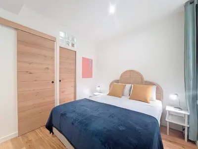 a bedroom with a large bed and a wooden door at Nestor&Jeeves - BEL AIR - City Center - Modern in Nice