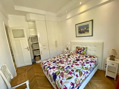 a bedroom with a bed with a floral comforter at Nice Hypercentre- Joli 2Pièces in Nice