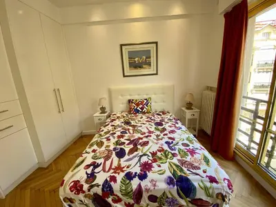 a bedroom with a bed with a flowered bedspread at Nice Hypercentre- Joli 2Pièces in Nice