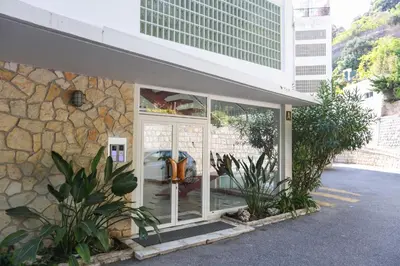 a building with a glass door with a stone wall at Appartement exception les pieds dans l'eau in Èze