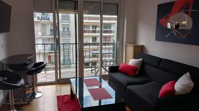 a living room with a couch and a large window at Very Nice Apartment in Nice