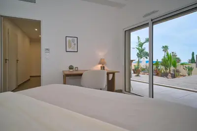 a bedroom with a bed and a desk and a window at Unique appartement à Nice vue mer imprenable in Nice