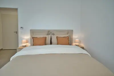 a bedroom with a large white bed with two lamps at Unique appartement à Nice vue mer imprenable in Nice