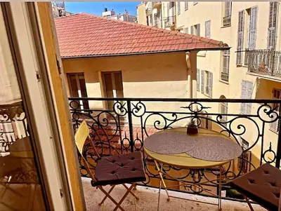 a balcony with a table and chairs on a balcony at Masséna street, 2 rooms balcony in Nice
