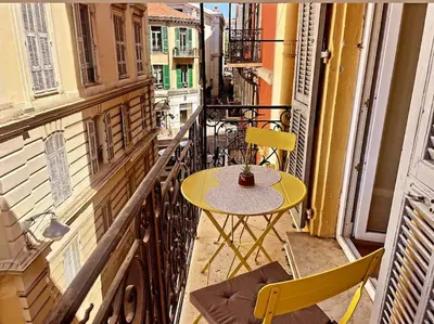 a yellow table and chairs on a balcony at Masséna street, 2 rooms balcony in Nice