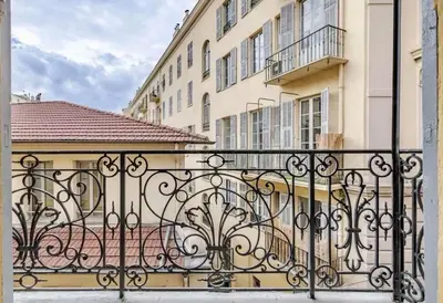 a black iron fence in front of a building at Masséna street, 2 rooms balcony in Nice