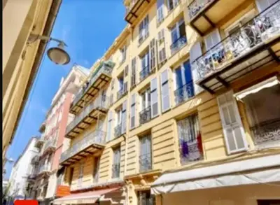 a tall yellow building with windows and balconies at Masséna street, 2 rooms balcony in Nice