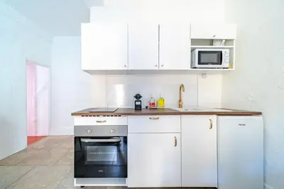 a white kitchen with white cabinets and a microwave at Charmant Appartement 2P au Cœur du Vieux Nice in Nice