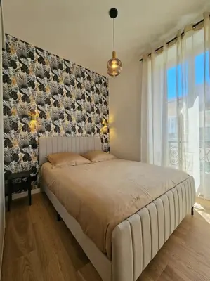 a bedroom with a large bed with a large window at Très bel appartement Nice centre in Nice