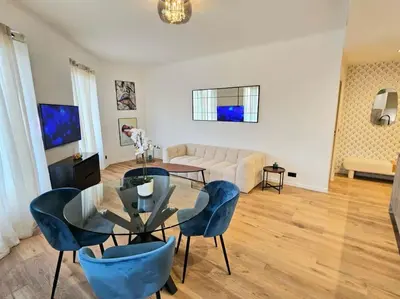 a living room with a glass table and blue chairs at Très bel appartement Nice centre in Nice