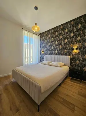 a bedroom with a large bed in front of a wall at Très bel appartement Nice centre in Nice