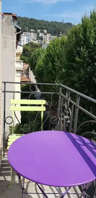 a purple table and a bench on a balcony at Appartement lumineux in Nice