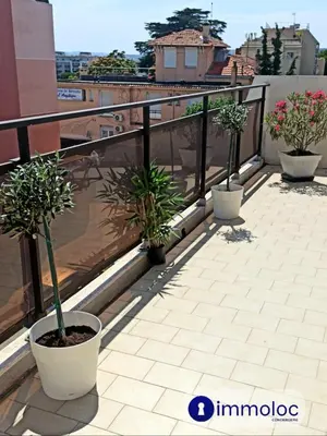 a balcony with three potted plants on a roof at Air-conditioned apartment with park and swimming pool à Cagnes in Cagnes-sur-Mer