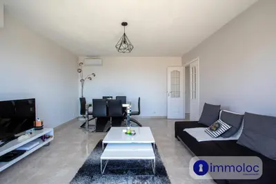 a living room with a couch and a tv at Air-conditioned apartment with park and swimming pool à Cagnes in Cagnes-sur-Mer