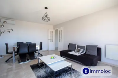 a living room with a couch and a table at Air-conditioned apartment with park and swimming pool à Cagnes in Cagnes-sur-Mer