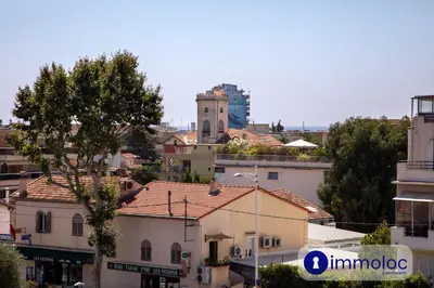 a city with buildings and a clock tower in the background at Air-conditioned apartment with park and swimming pool à Cagnes in Cagnes-sur-Mer