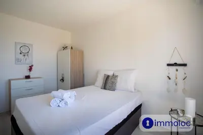 a bedroom with a white bed with towels on it at Air-conditioned apartment with park and swimming pool à Cagnes in Cagnes-sur-Mer
