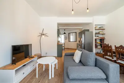 a living room with a couch and a tv and a table at Large & Quiet 1 Bdr Downtown in Nice