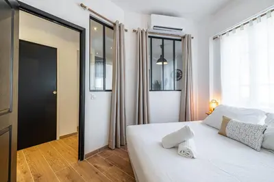 a bedroom with a white bed and a large window at Large & Quiet 1 Bdr Downtown in Nice