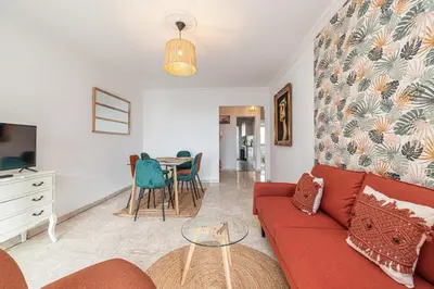 a living room with a red couch and a table at Large 2 Bdr Close to the Beach Balcony & Garage in Nice