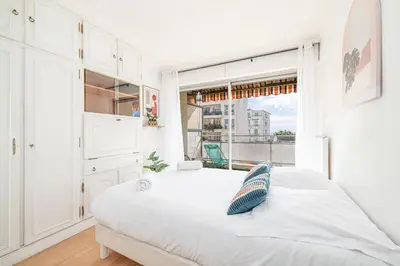 a white bedroom with a bed and a window at Large 2 Bdr Close to the Beach Balcony & Garage in Nice
