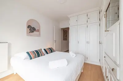 a white bedroom with a bed and white cabinets at Large 2 Bdr Close to the Beach Balcony & Garage in Nice