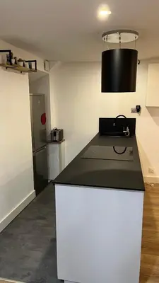 a kitchen with a black and white counter top at Appartement au port de Nice, proche des plages in Nice