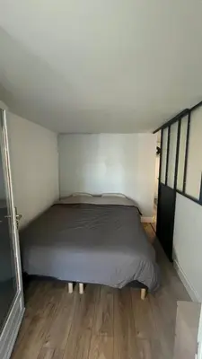 a bed in a small room with wood floors at Appartement au port de Nice, proche des plages in Nice
