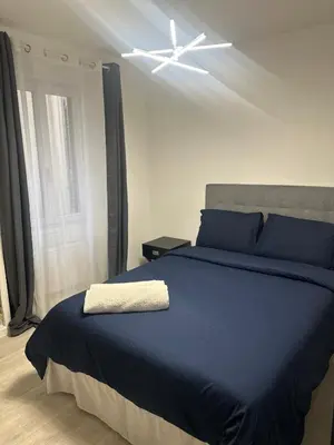 a bedroom with a blue bed with a ceiling fan at Carras in Nice