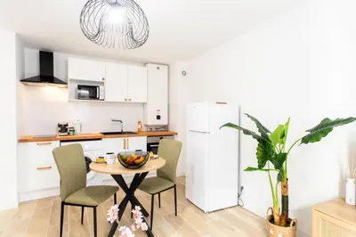 a kitchen with a table and chairs in a kitchen at #58 Logement Clim & Balcon 5mins marche de la Mer in Nice