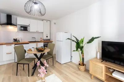 a kitchen with a table with chairs and a television at #58 Logement Clim & Balcon 5mins marche de la Mer in Nice