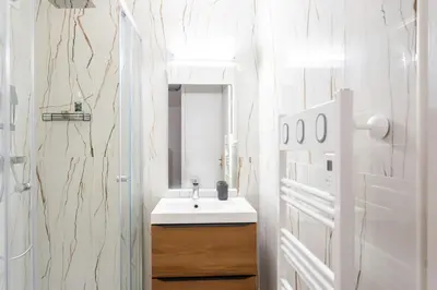 a white bathroom with a sink and a mirror at #58 Logement Clim & Balcon 5mins marche de la Mer in Nice