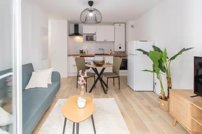 a living room with a couch and a table and a kitchen at #58 Logement Clim & Balcon 5mins marche de la Mer in Nice